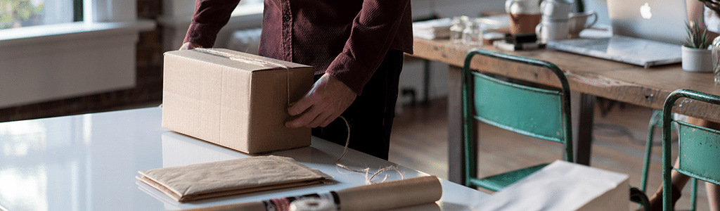 Ein Mann verpackt ein Paket auf einem Tisch 