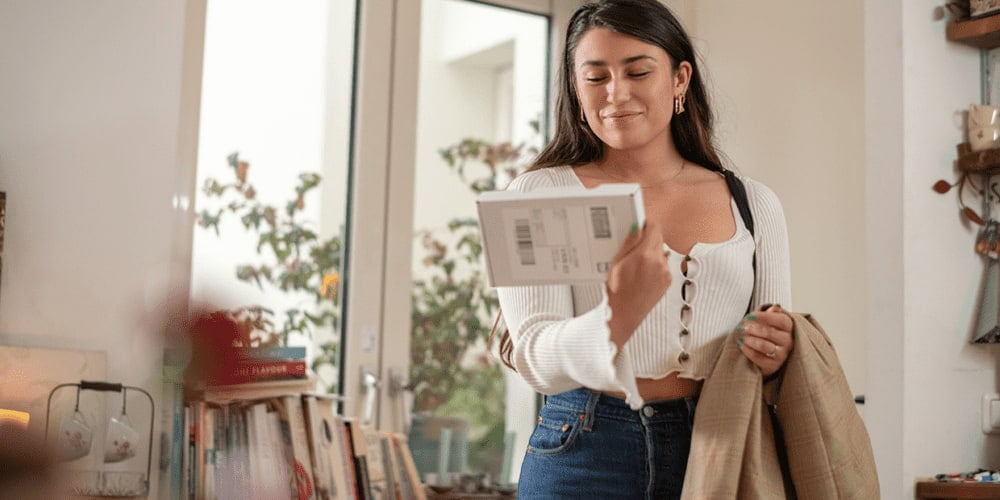 woman receives a package and smiles about the positive post-purchase experience 