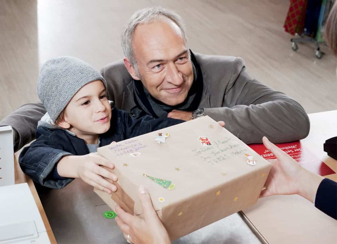 Großvater und Kind geben Paket für Weihnachten ab